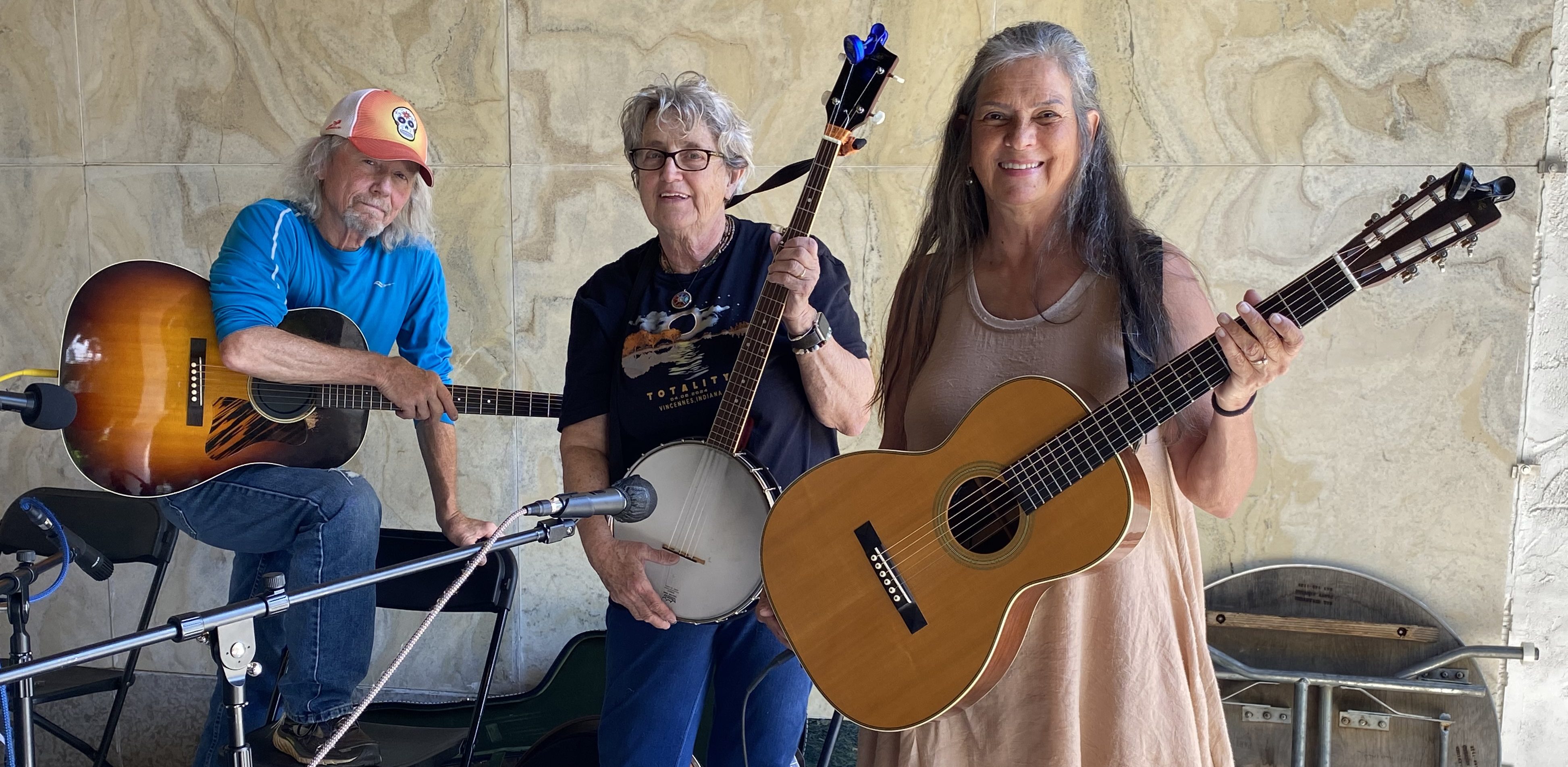 a band poses at Vestival with an acoustic guitar, a banjo, and another acoustic guitar
